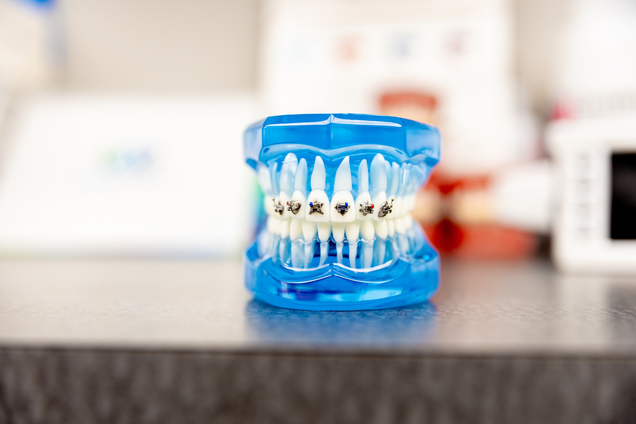 A photo of designer braces on fake teeth showing off the various shapes patients can choose from for their braces